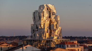 De spesialbelagte aluminiumspanelene på tårnfasaden reflekterer lyset fra kveldssolen, og skaper en nesten overnaturlig atmosfære. (© Adrian Deweerdt, Arles)