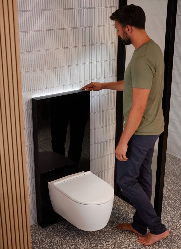 Mann ved siden av Geberit Monolith Plus med ComfortLight