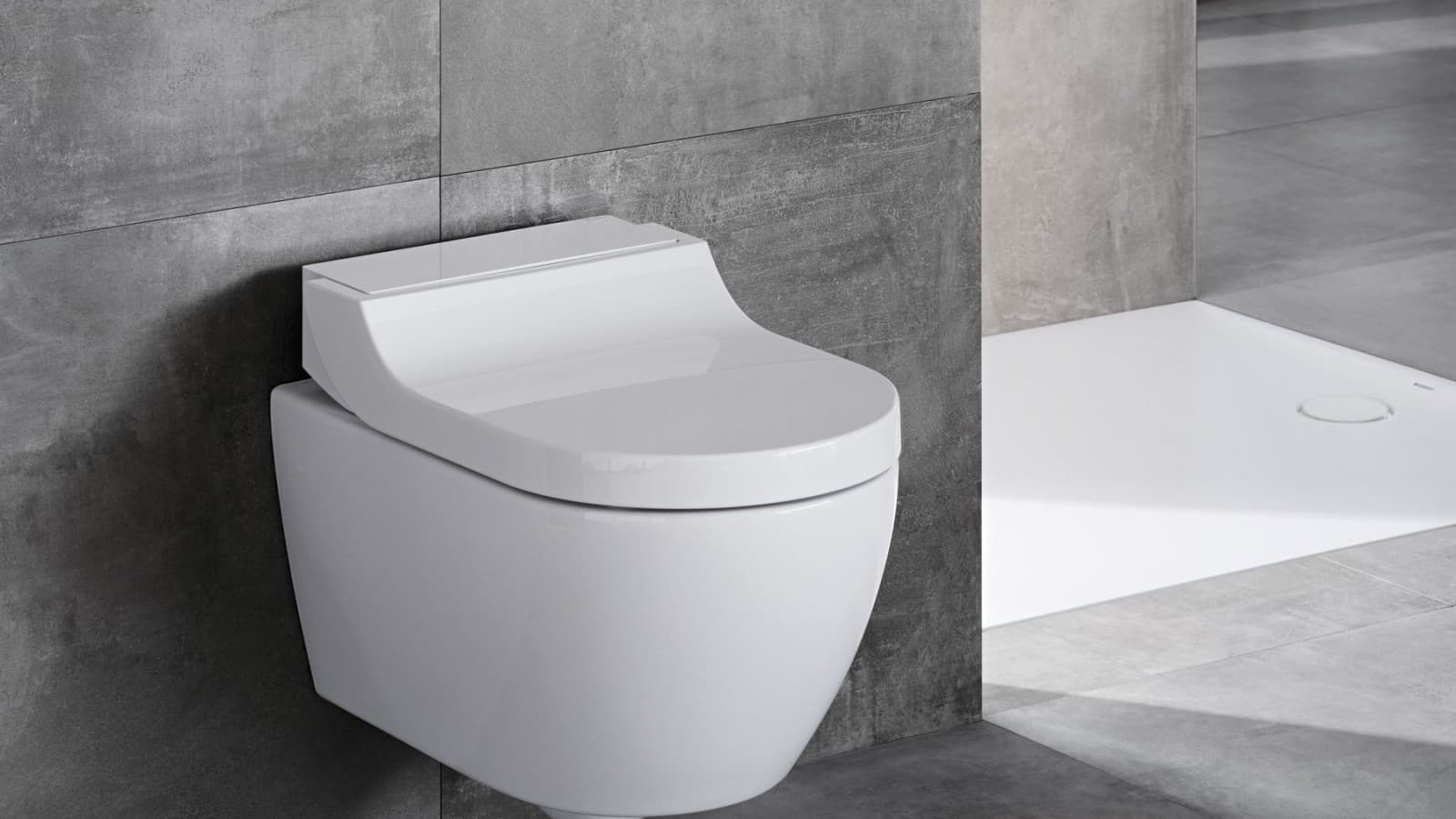 Dusjtoalettet Geberit AquaClean Tuma Classic på et grått baderom Dusjtoalettet Geberit AquaClean Tuma Classic på et grått baderom